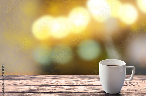 Cup of hot drink on bright background