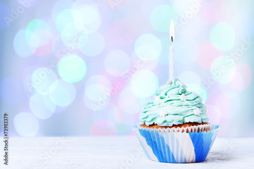 Delicious birthday cupcake on wooden table