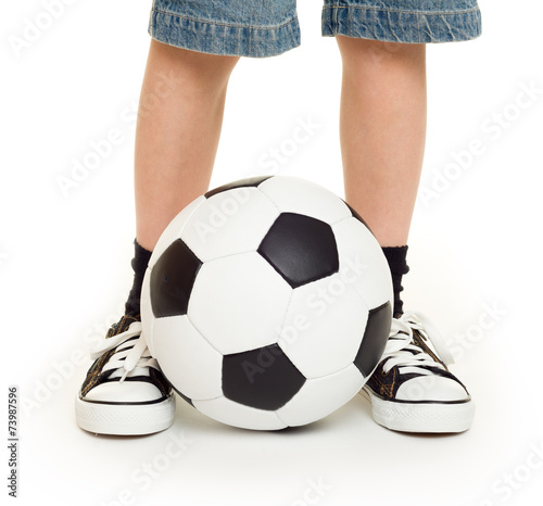 feet shod in sneakers and soccer ball
