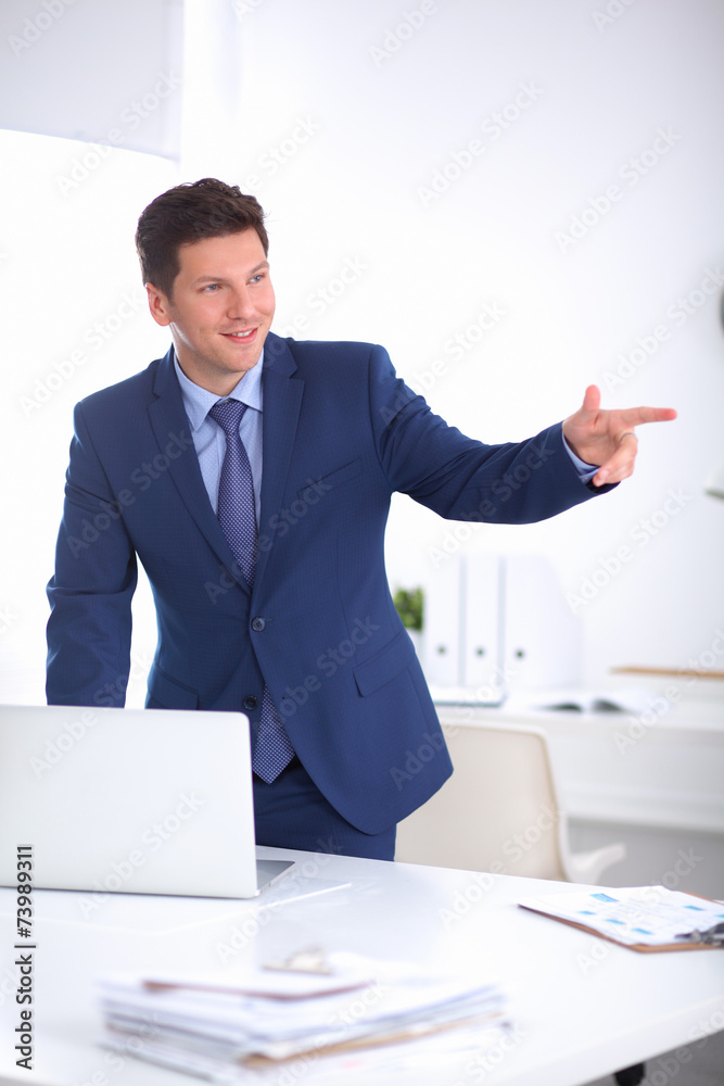 Confident successful young businessman leaning arms on his desk Confident successful young businessman leaning arms on his desk