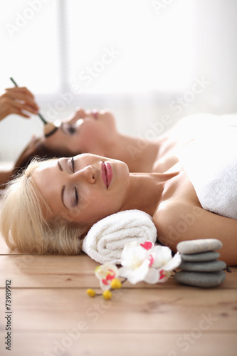 Two young beautiful women relaxing and enjoying at the spa