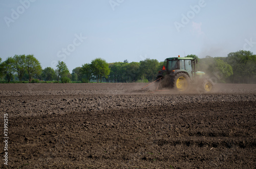 Obraz na płótnie Tractor in plowed field w salonie