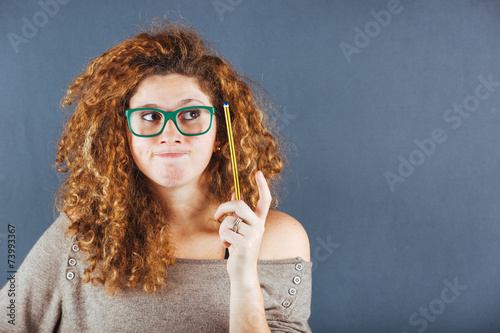 Pensive Curly Young Woman on Gray Background