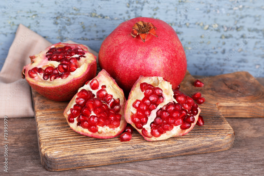 Juicy ripe pomegranates on old wooden table Juicy ripe pomegranates on old wooden table