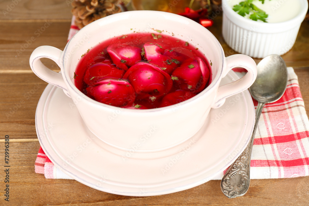 Traditional polish clear red borscht with dumplings in bowl Traditional polish clear red borscht with dumplings in bowl