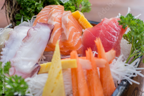 A colorful platter of sashimi sushi with tuna and crab sticks