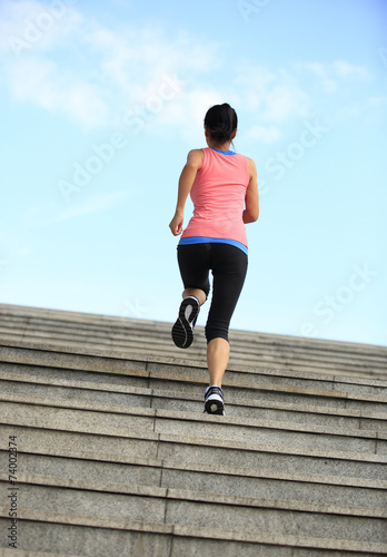 young fitness woman running up on stairs 