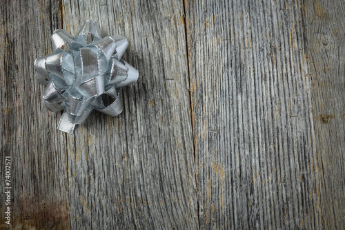 Silver Holiday Bow on Rustic Wood Background