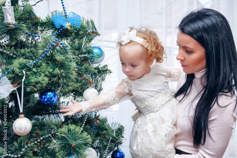 Happy mother and baby near Christmas tree Happy mother and baby near Christmas tree