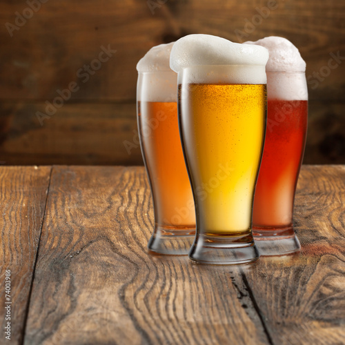 Different beer in glasses on wood