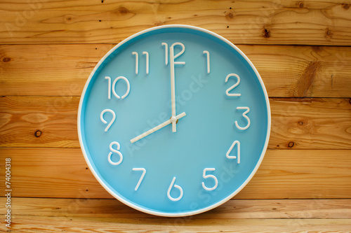 Large clock face on wood background.