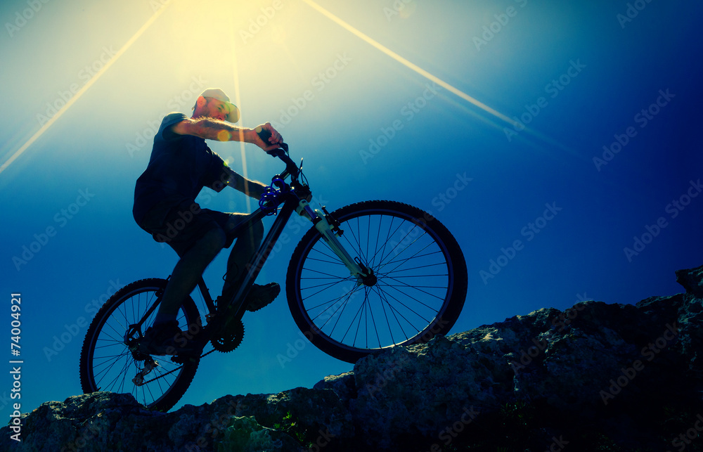 Fototapeta premium male cyclist on a mountain bike, backlit