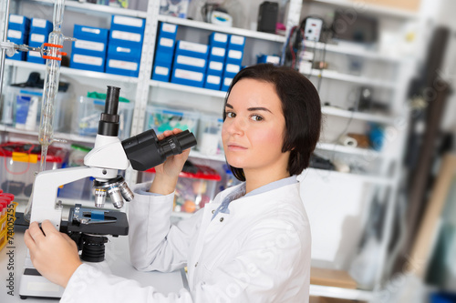 Scientist young woman using a microscope in a science laboratory