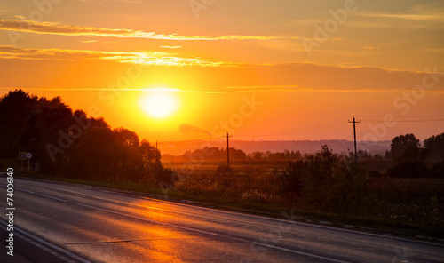 Orange sunset over asphalt road