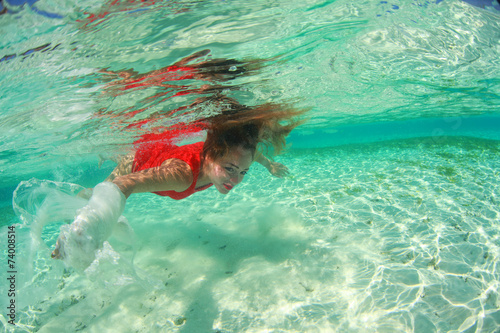 sexy redhead woman in red dress diving