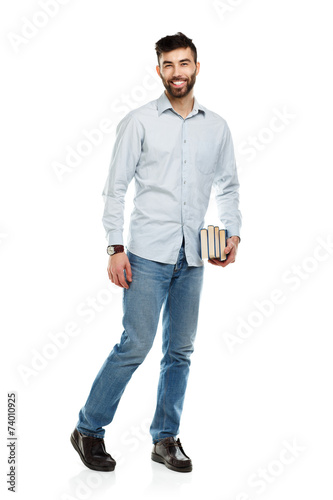 Young bearded smiling man with books in hands on white