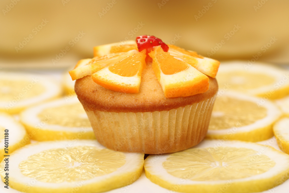 Delicious muffin surrounded by sliced yellow lemons Delicious muffin surrounded by sliced yellow lemons