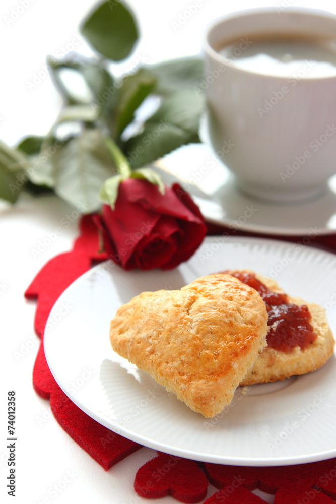 Heart shaped scones with strawberry jam and a cup of tea Heart shaped scones with strawberry jam and a cup of tea