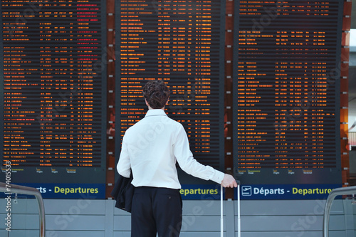 passenger looking at timetable board at the airport