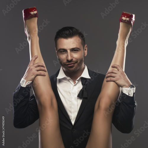Elegenat man sitting and is spreading a woman's legs