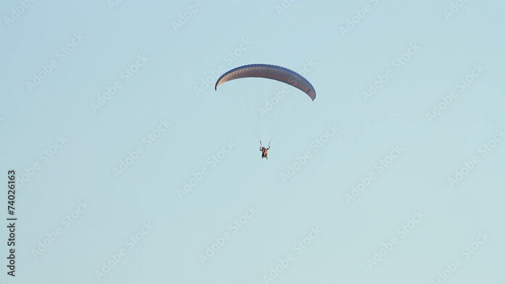 Paragliding over the mountains against clear blue sky