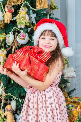 Happy little girl with christmas present smiling