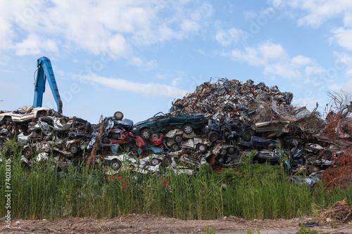 Φωτογραφία Scrap yard with crushed cars and blue sky