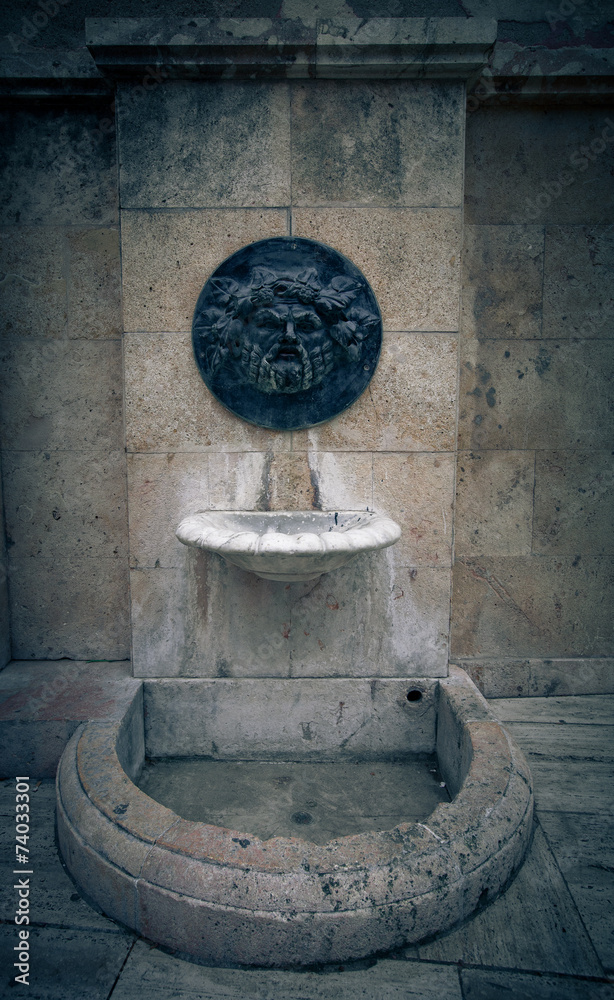 Old broken drinking fountain in the Spanish city. Tinted Old broken drinking fountain in the Spanish city. Tinted