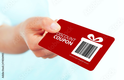 red christmas coupon holded by hand over white