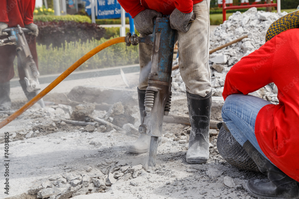 worker using construction drilling cement on the ground worker using construction drilling cement on the ground