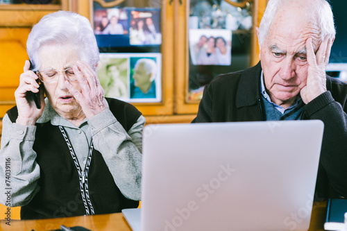 Foto Senior couple working with Laptop at home