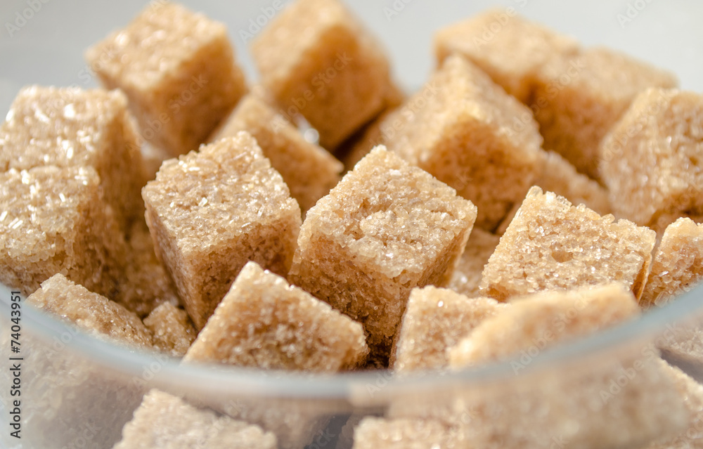Brown cubes of cane sugar in the glass cup Brown cubes of cane sugar in the glass cup