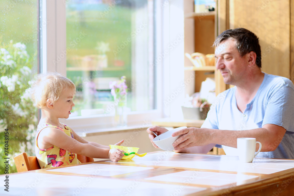 Father and daughter having breakfast in the kitchen Father and daughter having breakfast in the kitchen