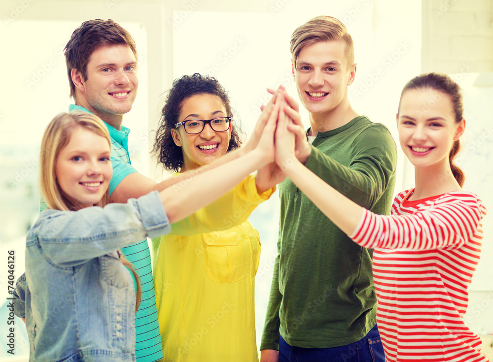 five smiling students giving high five at school five smiling students giving high five at school
