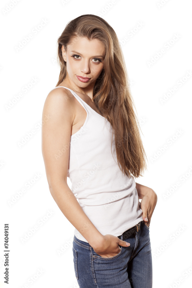 beautiful young woman in jeans posing on a white background beautiful young woman in jeans posing on a white background