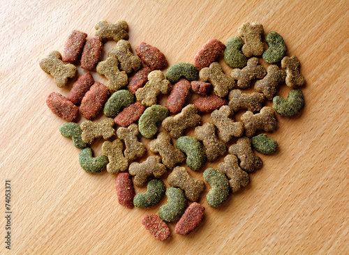 Dry dog food in heart shape on the table