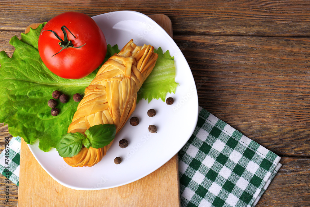 Smoked braided cheese on wooden table Smoked braided cheese on wooden table