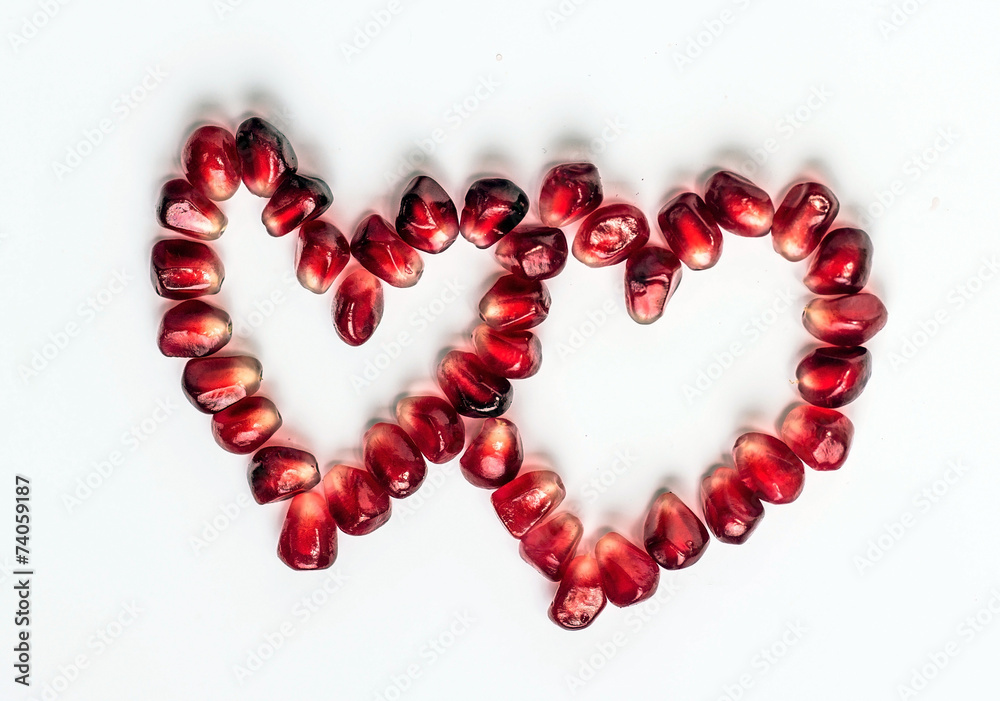 two hearts of pomegranate seeds isolated on white background two hearts of pomegranate seeds isolated on white background