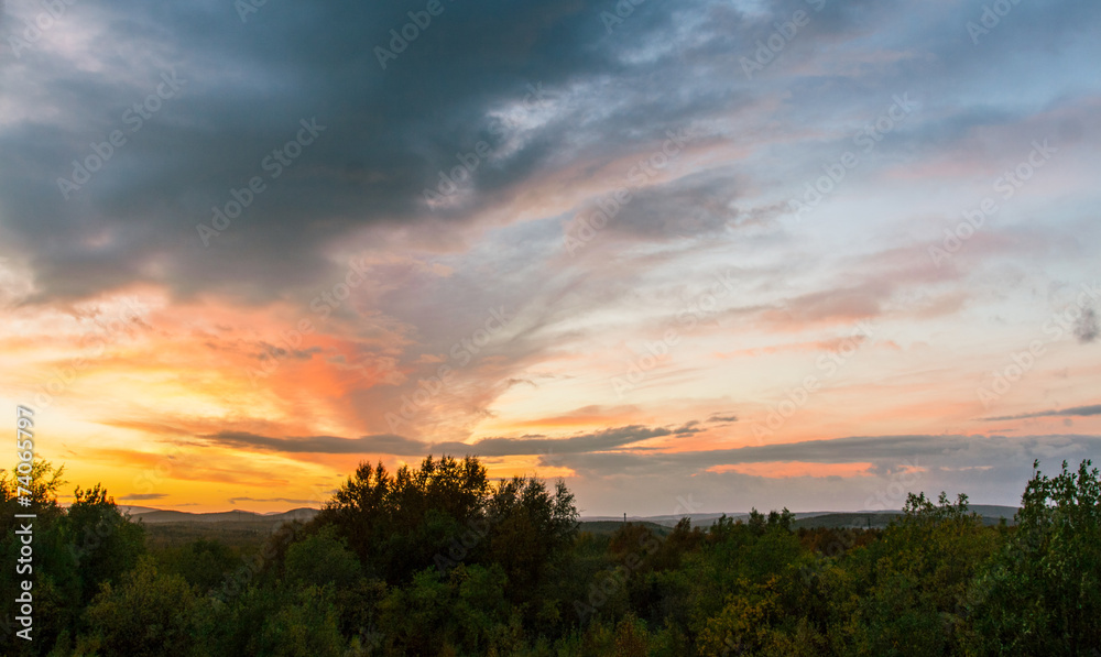 Summer sunset over the hills covered with forest