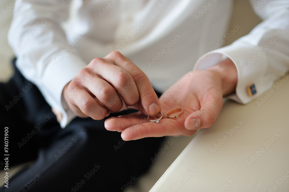 Fototapeta premium groom holding a gold rings