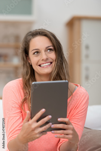 frau mit tablet schaut glücklich nach oben