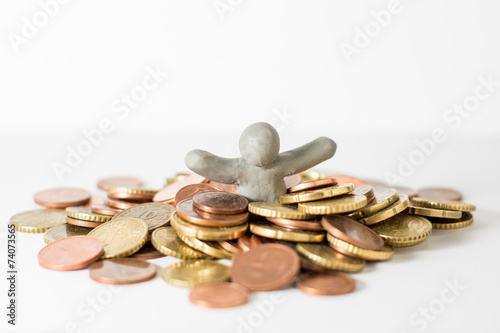 Plasticine man immersed in coins