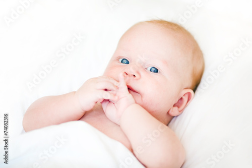 Peaceful newborn baby lying on a bed