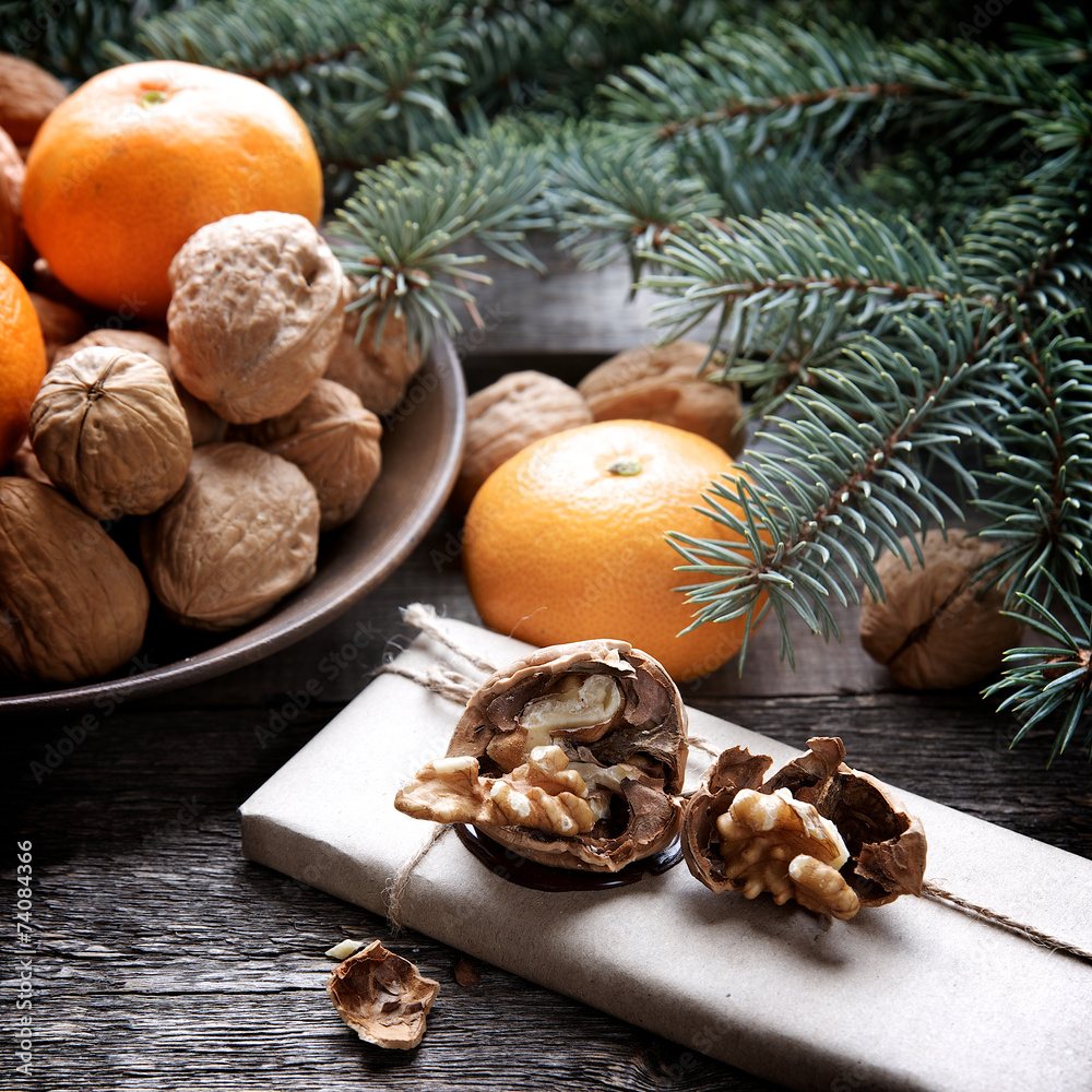 Walnuts and tangerines on a background of fir branches Walnuts and tangerines on a background of fir branches