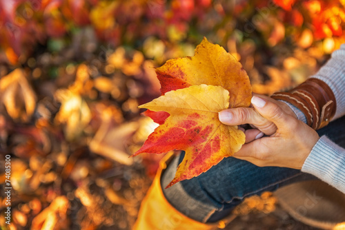 Closeup on woman holding autumn leaf