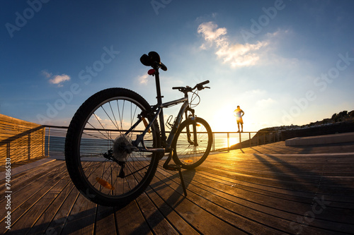 silhouette of sportsman and mountain bike at the sunset