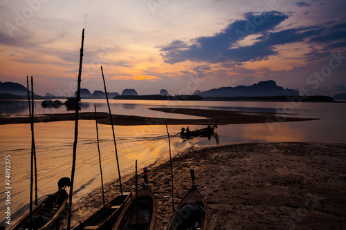Silhouette of fisherman and traditional thai boats at Sam chong