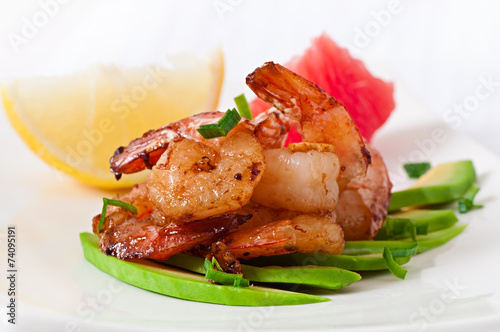 Shrimp sauteed with garlic and soy sauce on a cushion of avocado