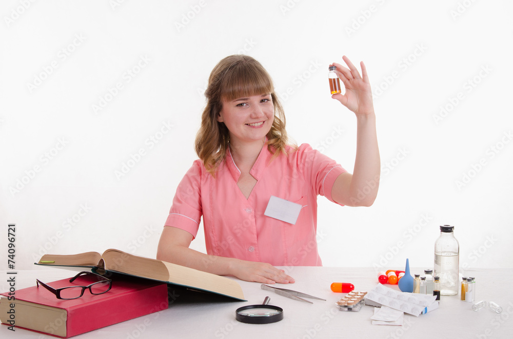 Pharmacist sitting at a table with an ampoule Pharmacist sitting at a table with an ampoule