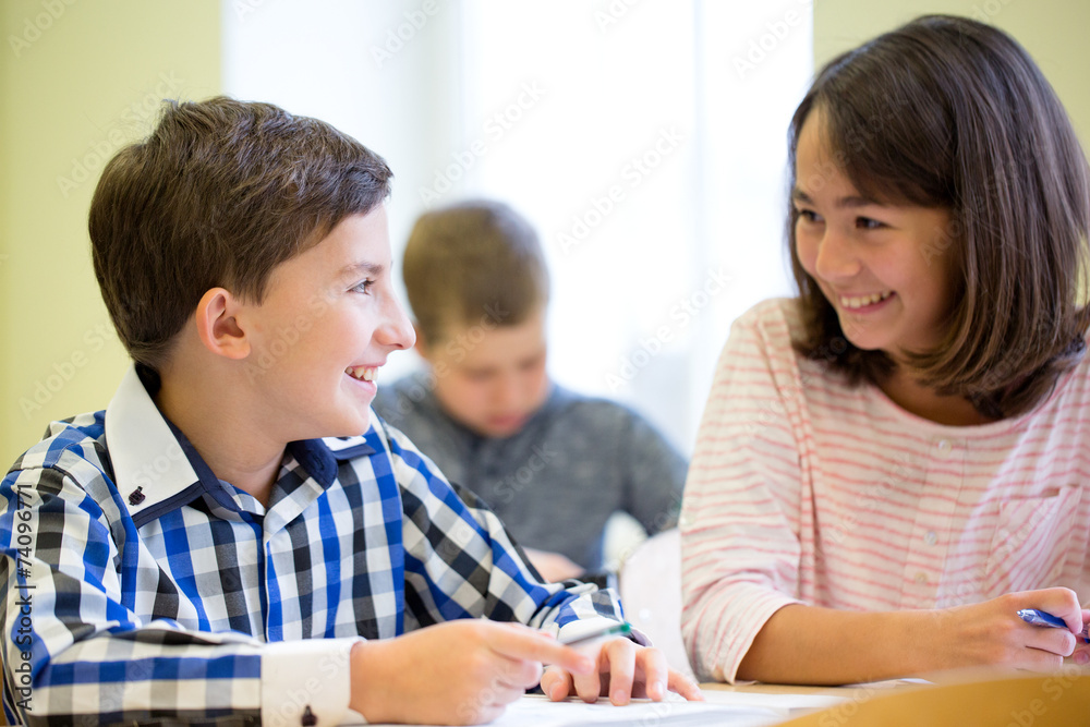 group of school kids writing test in classroom group of school kids writing test in classroom